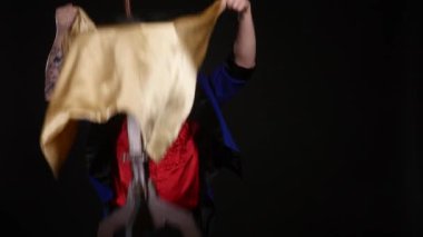 Profesyonel sihirbaz tablo yanılsama uçan gerçekleştirir. Muhteşem görünüyor. Siyah bir arka plan üzerinde ateş