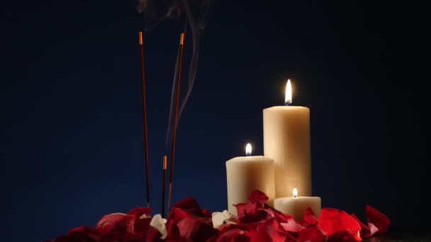 Ладан палочки и свечи горят и дым на темном фоне, дым от ладана и свечи — стоковое видео