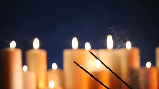 Запалення палички аромату на тлі запалених свічок — стокове відео