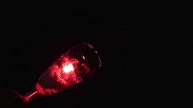 köpük siyah bir zemin üzerine bir bardak. Arkada pembe bir filtre ile projektörler