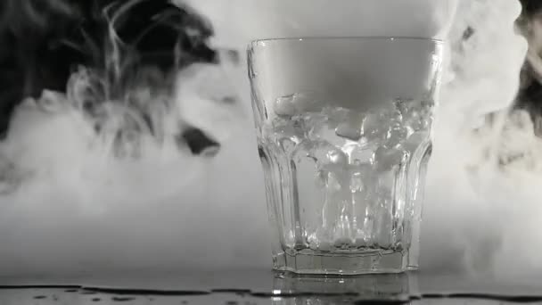 Fumée blanche abstraite dans le verre l'effet de la glace sèche sur fond sombre — Video