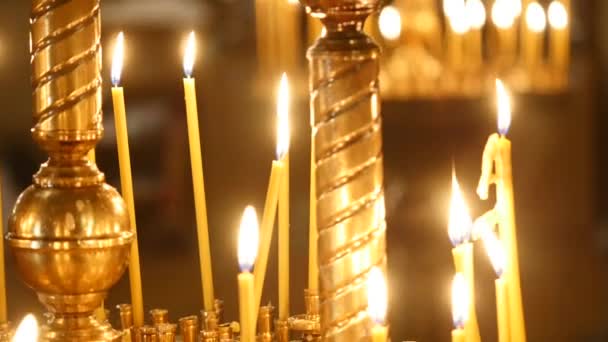 Свічки, що палають у свічнику в церкві — стокове відео