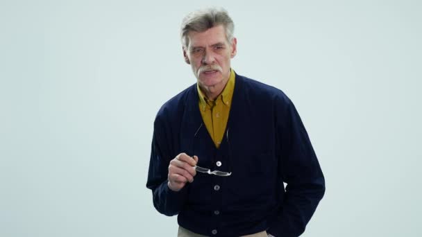 Expressieve oude man denken geïsoleerd tegen witte achtergrond — Stockvideo