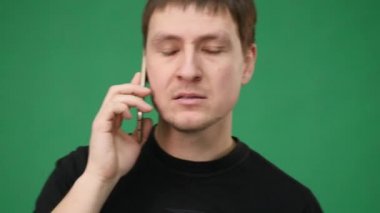 Cep cep telefonu üzerinde yeşil arka plan izole çığlık öfkeli iş adamı
