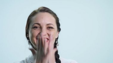 Gülümseyerek, beyaz arka plan üzerinde sevindirici genç güzel kadın