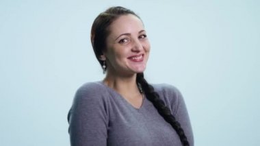 Gülümseyerek, beyaz arka plan üzerinde sevindirici genç güzel kadın