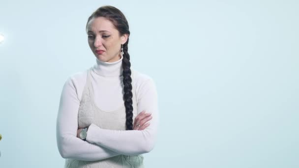 Молодая грустная женщина плачет на белом фоне — стоковое видео