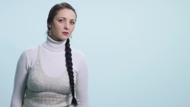 Молодая женщина заглядывает на белый изолированный фон — стоковое видео