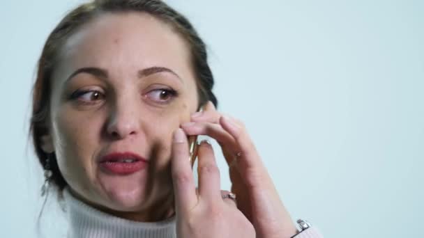 Lächeln glückliche junge Frau spricht auf Handy isoliert über weiß — Stockvideo