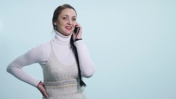 Boldog mosolygó fiatal nő beszélt a mobil, elszigetelt, felett fehér — Stock videók