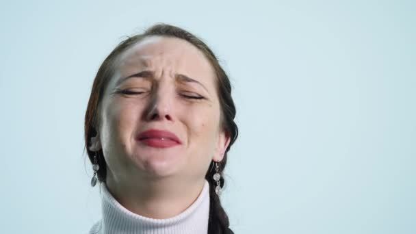 Joven mujer triste llorar sobre fondo blanco — Vídeo de stock