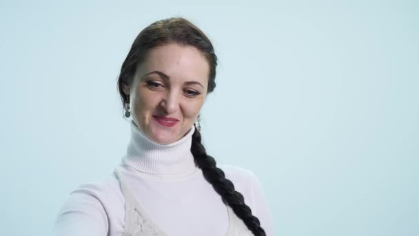 Κοντινό πλάνο της νεαρής γυναίκας χέρι που κρατά το κλειδί σε λευκό φόντο — Αρχείο Βίντεο