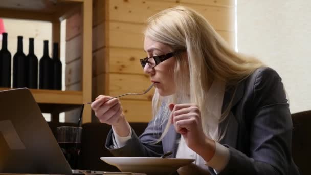 Kobieta interesu obiad i działa na laptopie w kawiarni — Wideo stockowe