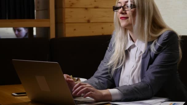 Jovem mulher trabalhando no laptop moderno no café — Vídeo de Stock