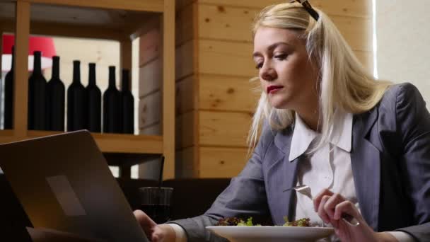 Empresaria almorzando y trabajando en laptop en la cafetería — Vídeo de stock