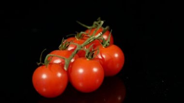 Grup siyah arka plan üzerine dönen küçük domates
