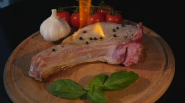 yakından görmek ham parça et ve biber biber Kıyma Kurulu siyah alev ile. Sulu domates baharatlar tuz özel lezzetli yemekler lezzetli beslenme hazırlanıyor ızgara sığır eti biftek Barbekü alevler ateş