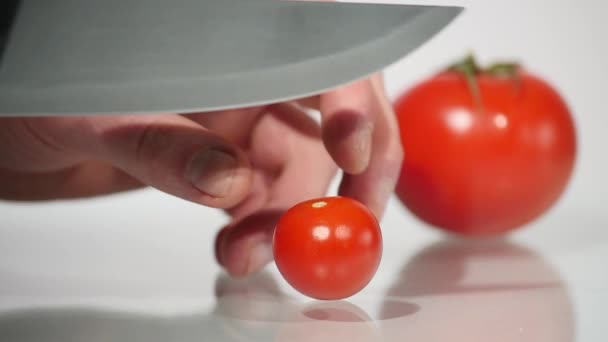Γκρο πλαν, κοπή μια ντομάτα σε λευκό φόντο — Αρχείο Βίντεο