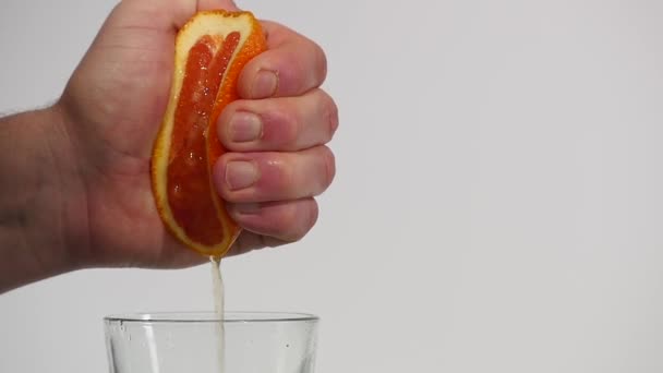 Männliche Hand, die frischen Orangensaft presst. — Stockvideo