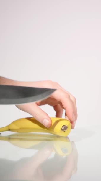 Hombre rebanando plátano con cuchillo grande — Vídeo de stock