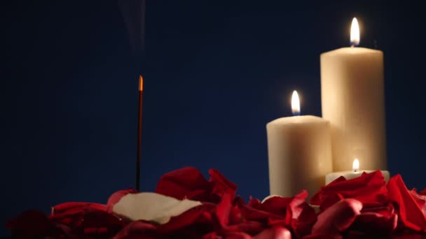 Räucherstäbchen und Kerzen brennen und Rauch auf dunklem Grund, Rauch von Weihrauch und Kerzenschein — Stockvideo
