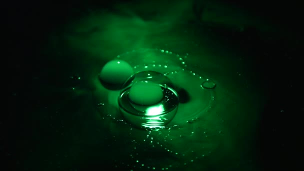 Green soap bubbles with smoke on black background — Stock Video