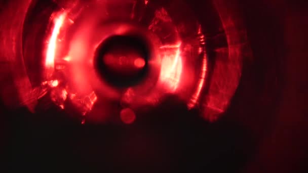 Een glas met schuim op een zwarte achtergrond. Floodlight met een roze filter in de rug. Close-up — Stockvideo