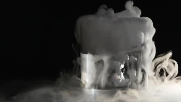 Abstrakter weißer Rauch im Glas die Wirkung von Trockeneis auf dunklem Hintergrund — Stockvideo
