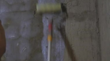 Onarım çalışmaları, astar ve beyaz boya, beyaz astar ile bir rulo veya fırça, fırçalar tavan ile çıplak beton duvar boyama.