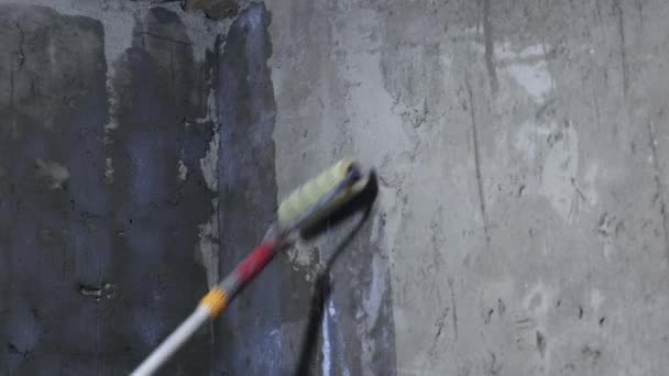 Працівник малює стіну з фарбою-роликом — стокове відео