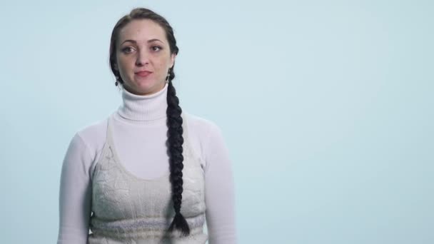 Молодая женщина делает не знаю знак на белом фоне — стоковое видео