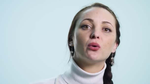 Junge Frau blickt auf weißen isolierten Hintergrund — Stockvideo