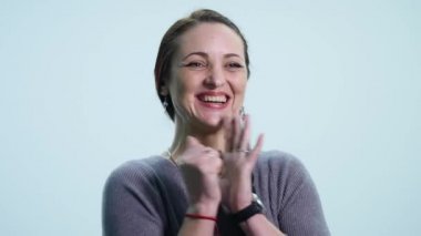 Gülümseyerek, beyaz arka plan üzerinde sevindirici genç güzel kadın