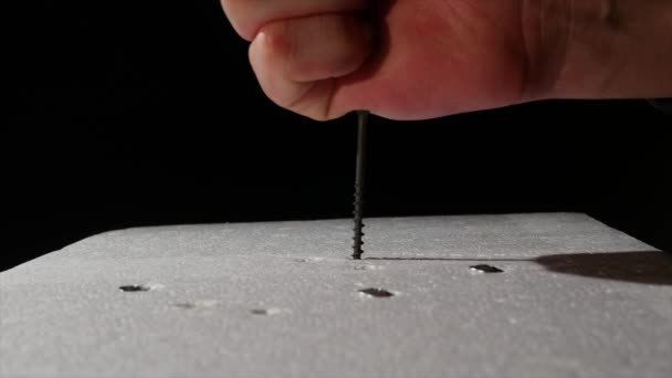 The man twists the screws into the foam using a screwdriver — Stock Video