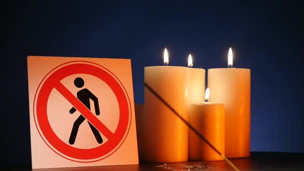 Многие горящие светлые восковые свечи с размахивающим желтым пламенем со знаком для людей вход запрещен на черном фоне. Круглые горящие палки для празднования событий и молнии — стоковое видео