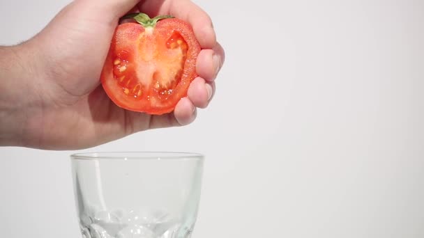 La mano exprime el jugo del tomate — Vídeo de stock