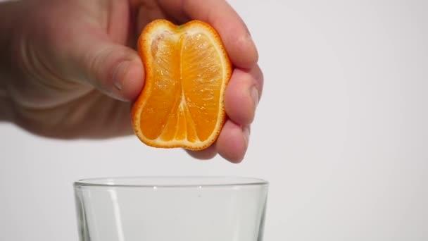 Mano masculina exprimiendo jugo de naranja fresco.Mano exprimiendo una naranja — Vídeo de stock