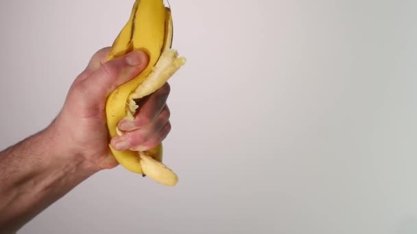 维生素和健康的饮食。成熟醇厚的香蕉果挤压, 捣碎, 或粉碎与黄色皮肤和肉滴, 溅, 在白色背景 — 图库视频影像