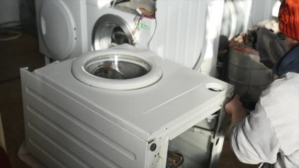 Un riparatore sta smantellando completamente un pannello di controllo sulla lavatrice. Deve riparare l'intero dispositivo. . — Video Stock