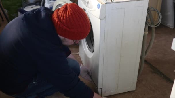 Un reparador está desmontando completamente un panel de control en la lavadora. Necesita arreglar todo el dispositivo. . — Vídeo de stock