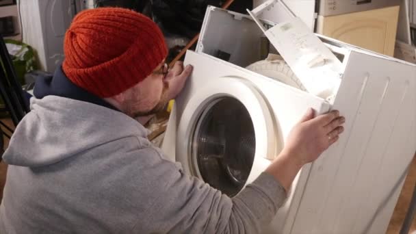 Man försöker fixa tvättmaskinen — Stockvideo