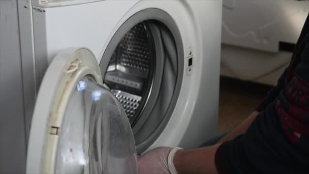 Mann versucht Waschmaschine zu reparieren — Stockvideo