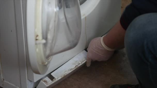 Чоловік намагається виправити пральну машину — стокове відео