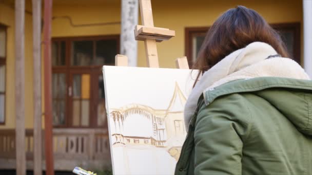 Fiatal művészek dolgoznak a városban. Művészek festeni a képet az utcán. Diákok festeni a régi európai város épület — Stock videók