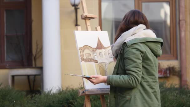 Giovani artisti disegnano in città. Artisti che dipingono quadri per strada. Gli studenti dipingono la costruzione della vecchia città europea — Video Stock