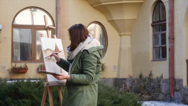 De jeunes artistes dessinent dans la ville. Artistes peinture tableau dans la rue. Les étudiants peignent la construction de la vieille ville européenne — Video