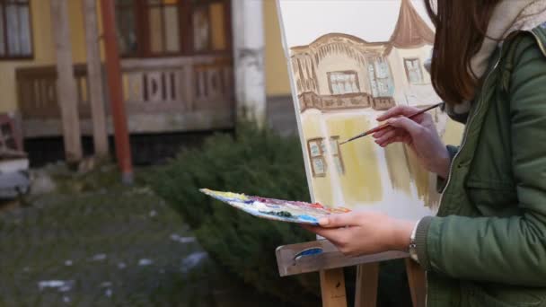 Meisje kunstenaar hand schilderij in oude straat — Stockvideo