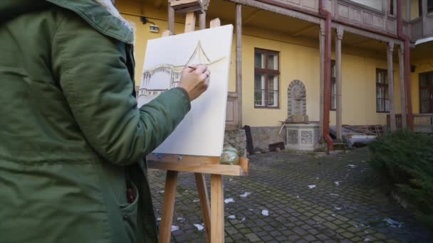 Jonge kunstenaars tekenen in de stad. Kunstenaars schilderen foto op straat. Studenten schilderen gebouw van de oude Europese stad — Stockvideo