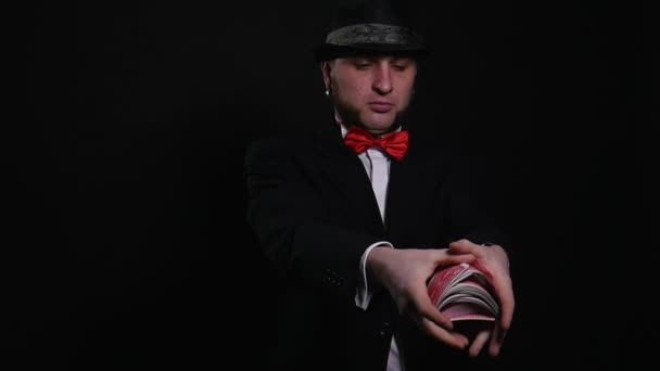 Jonge goochelaar toont speelkaart magische truc Toon begrip truc op zwarte achtergrond — Stockvideo