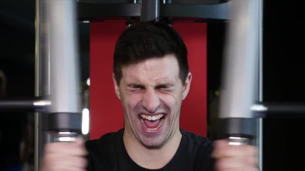 Man with a sports figure doing exercise on simulator in the gym — Stock Video